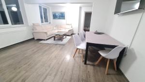 瓦特拉多尔内Apartament In Inima Dornei的客厅配有桌椅和沙发