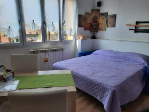 德尔维奥Appartamento Yuki的卧室配有床、桌子和窗户。