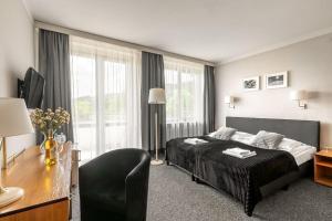 扎科帕内太阳神酒店的酒店客房配有一张床、一张书桌和一张西德西德西德西德床