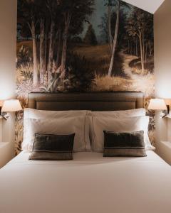 里斯本AlmaLusa Alfama的卧室配有带枕头的床上方绘画