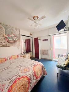 马拉加弗拉门戈卡马龙旅馆的一间卧室配有一张床和吊扇