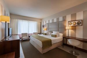 厄尔-汝姆披多朗皮多精品度假酒店的酒店客房设有一张大床和一张书桌。