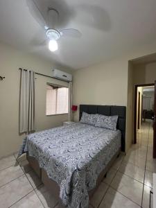 瓦拉达里斯州长市Andres' Home Vila Bretas的一间卧室配有一张床和吊扇