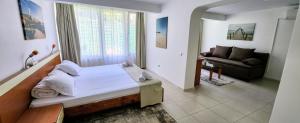 南埃福列维拉阿库阿的一间卧室配有一张床,客厅配有沙发