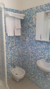 马里纳-迪-皮特拉桑塔MILANO的蓝色瓷砖浴室设有水槽和卫生间
