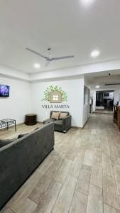 圣安娜Hostal Villa Marta的客厅配有沙发和桌子