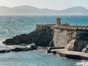 皮昂比诺Bilocale vista mare al Castello的海边悬崖上的灯塔