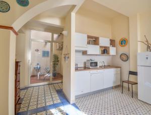 皮昂比诺Bilocale vista mare al Castello的厨房配有白色橱柜和台面