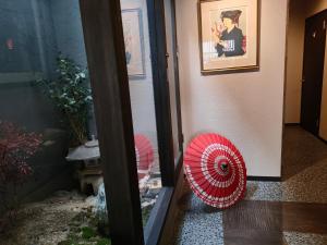 京都Mini Inn Kyoto 京都 - 外国人向け - 日本人予約不可的门旁地板上两把红伞