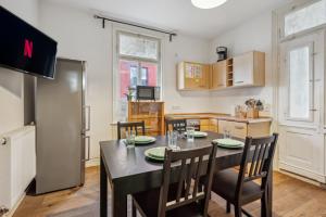 梅青根home2stay worker Apartments Metzingen的一间带桌椅的厨房和一间带冰箱的厨房