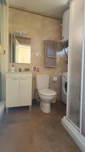 米哈斯Sun Love calypso的浴室配有卫生间、盥洗盆和洗衣机。