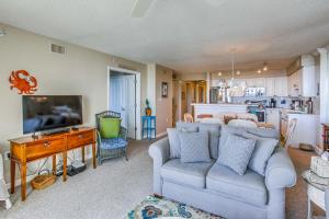 帕瓦雷斯岛Pawleys Island Condo - Balcony, Pool and Ocean Views的一间带蓝色沙发的客厅和一间厨房