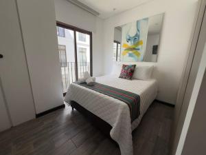 危地马拉L1C 301 - Boutique apartment in Cayala for 4 guests的卧室配有一张床,墙上挂有绘画作品