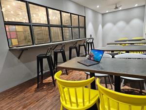 浦那Coliwo Trois - Kharadi的用餐室配有黄色椅子和笔记本电脑桌