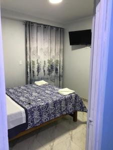 曼克拉Áncora Beach Hotel的一间卧室配有一张带蓝白色毯子的床