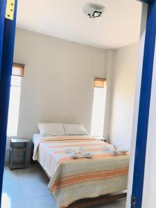 曼克拉Áncora Beach Hotel的一间卧室设有一张床和两个窗户。