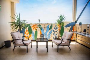 皮乌拉LC Hoteles Piura的壁画阳台配有两把椅子和一张桌子