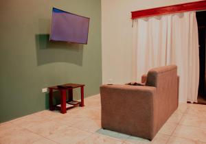 福尔图纳Wild Arenal Village的客厅配有椅子和平面电视