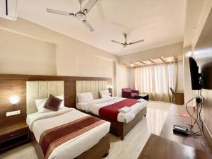 瓦拉纳西Hotel Rudraksh ! Varanasi ! fully-Air-Conditioned hotel at prime location with Parking availability, near Kashi Vishwanath Temple, and Ganga ghat的酒店客房设有两张床和电视。
