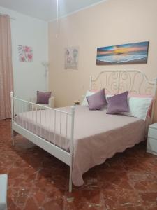 圣维托罗卡波Casa Blanca的卧室内的白色床和紫色枕头