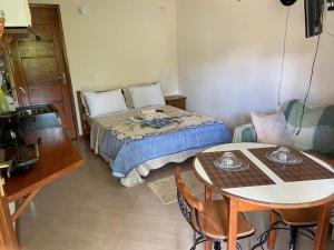 卢米亚Estalagem O Italiano的卧室配有1张床、1张桌子和1张桌子以及椅子。