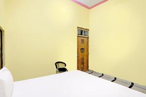 JhājharOYO J.M.D Restaurant &rooms的一间带两张床的卧室和木制架子