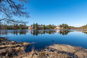 StrömsbrukBed & Breakfast de Jager的享有大湖的背景树木美景