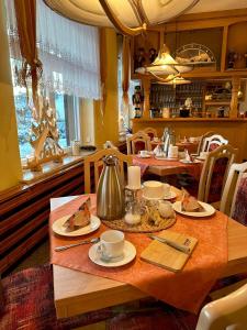 库罗阿尔滕堡海伦尼豪夫酒店的用餐室配有餐桌和食物