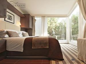 切尔维亚Hotel Miramare - SPA & Suites - Breakfast & Brunch Until 13-00的一间卧室设有一张大床和一个大窗户