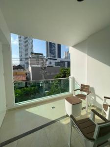 卡塔赫纳Miami Hotel Cartagena - Luxury Apartments的市景阳台配有椅子