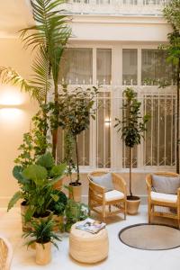 加的斯Plaza Mina Suites - Adults Recommended by Luxury Suites Cadiz的一间布满植物和椅子的房间