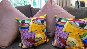 维德尼斯Kaaimans Retreat - River Front - No Loadshedding的沙发上坐着三个色彩缤纷的枕头