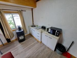 特木科Alojamiento Temuco的客房设有带微波炉和柜台的厨房。