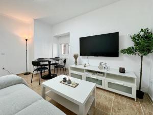 阿维拉Oasis Suite的白色的客厅配有电视和桌子