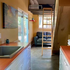 里昂WeeCasa Tiny Home Resort的厨房配有水槽和沙发