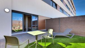 阿尔考本达斯Livensa Living Studios Madrid Alcobendas的大楼内带桌椅的天井