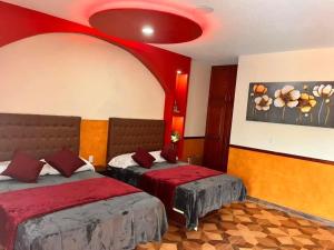 卡西塔斯Hotel La Cueva del Pirata的一间卧室设有两张床和红色天花板