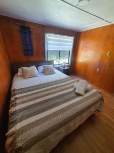 卡斯特鲁Hostal Isla Mágica的一间卧室配有一张带木墙的大床