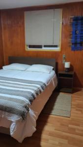 卡斯特鲁Hostal Isla Mágica的一间卧室配有一张带窗户和木地板的床。