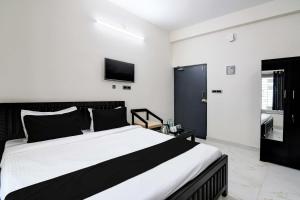 KhandagiriOYO Flagship SS INN Hotels & Homes的一间卧室设有一张大床和一台墙上的电视。