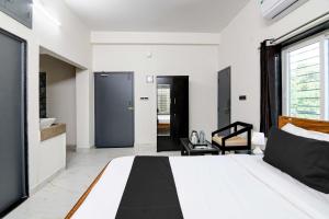 KhandagiriOYO Flagship SS INN Hotels & Homes的一间带大床的卧室和一间浴室
