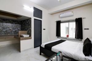 KhandagiriOYO Flagship SS INN Hotels & Homes的一间卧室设有床、窗户和水槽