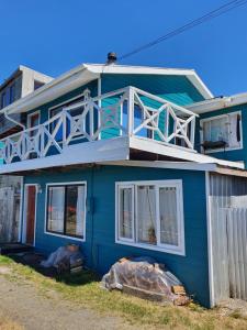 卡斯特鲁Hostal Isla Mágica的蓝色房子的顶部设有阳台