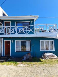 卡斯特鲁Hostal Isla Mágica的前面有一只狗的蓝色房子