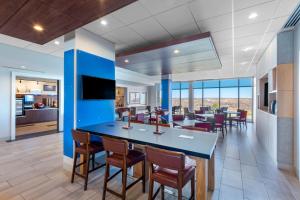 科罗拉多斯普林斯Holiday Inn Express & Suites - Colorado Springs South I-25, an IHG Hotel的用餐区,房间中间有一个蓝色的大岛