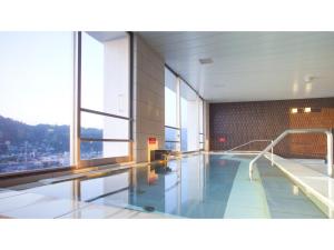 高山Spa Hotel Alpina Hida Takayama - Vacation STAY 51628v的一座带大窗户的建筑中的游泳池