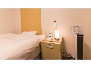 高山Spa Hotel Alpina Hida Takayama - Vacation STAY 51628v的一间卧室,配有一张床和床头灯