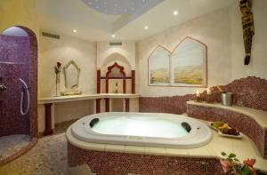 洛伊塔施拉菲斯酒店的大型浴室设有浴缸和淋浴。