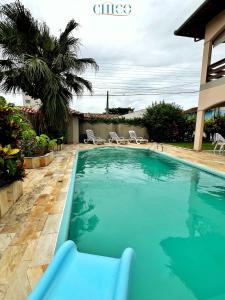 纳韦甘蒂斯Pousada Casa Chico的一个带椅子的庭院和房子的游泳池