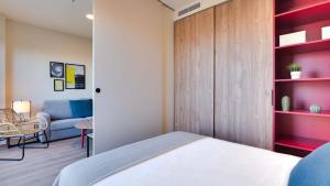 阿尔考本达斯Livensa Living Studios Madrid Alcobendas的一间卧室配有一张床和一张沙发
